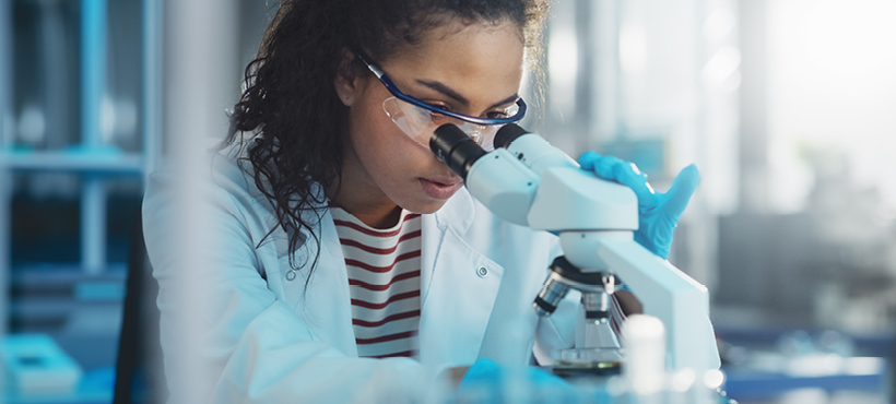 Medial student looking into a microscope
