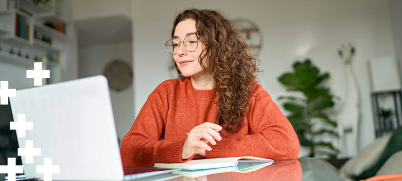 Student sat at a desk working on a laptop