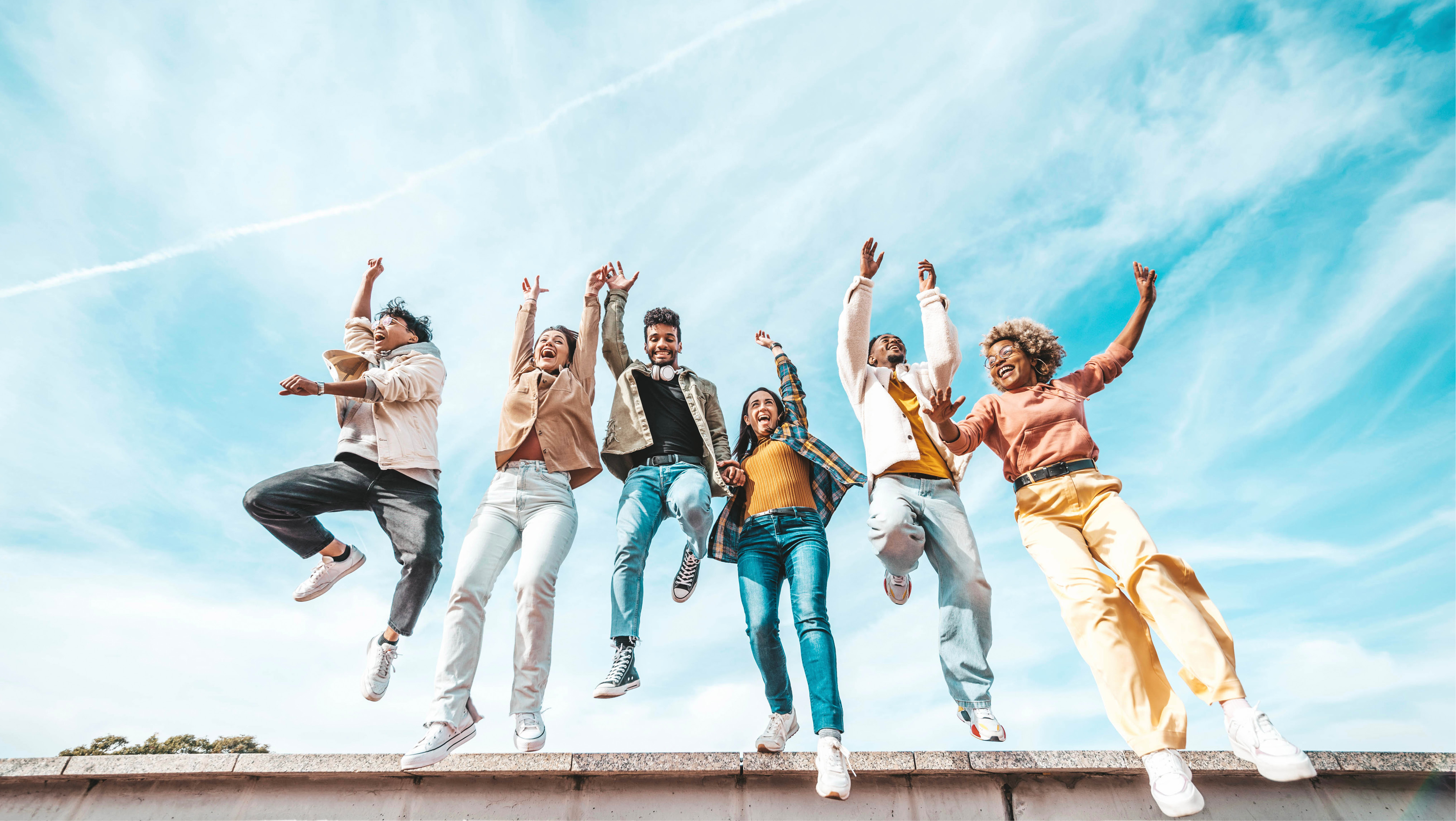 Six people jumping into the air and cheering Six people jumping into the air and cheering