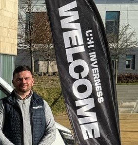 Man standing by a welcome sign