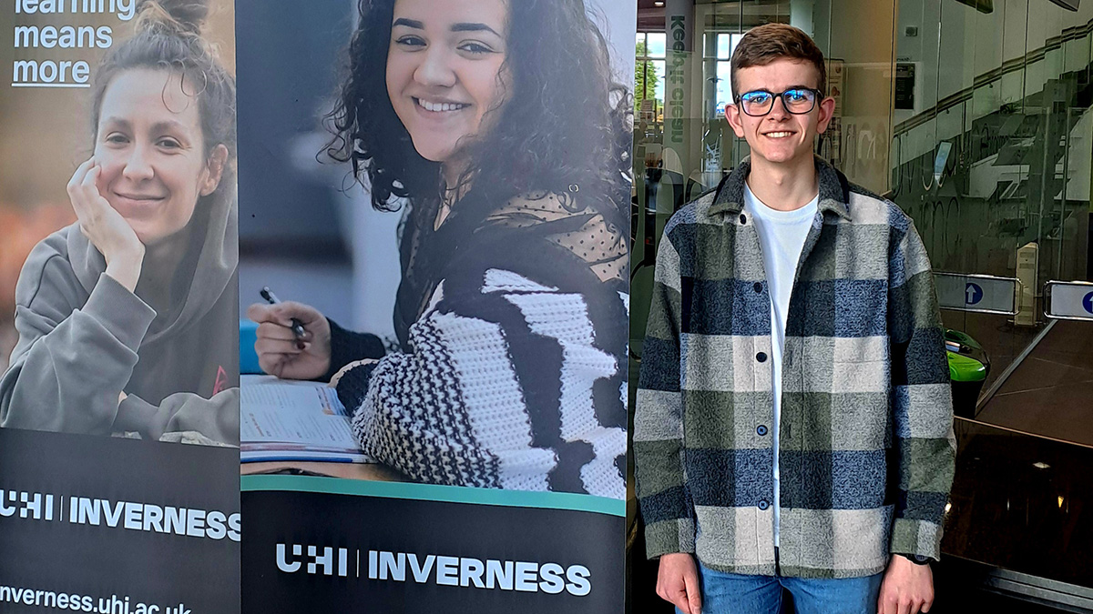 Student Archie Webster standing next to college sign Student Archie Webster standing next to college sign
