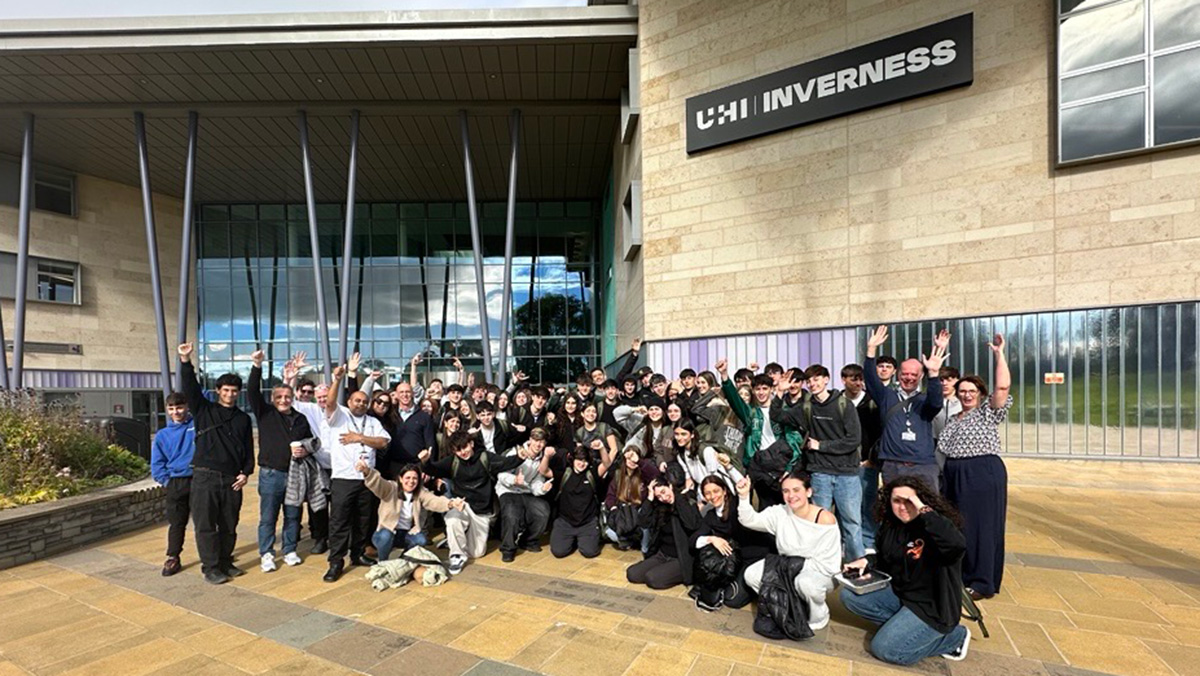Large group of students and staff outside a college campus