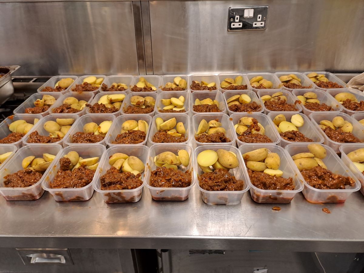 A table with cartons full of mince and tatties