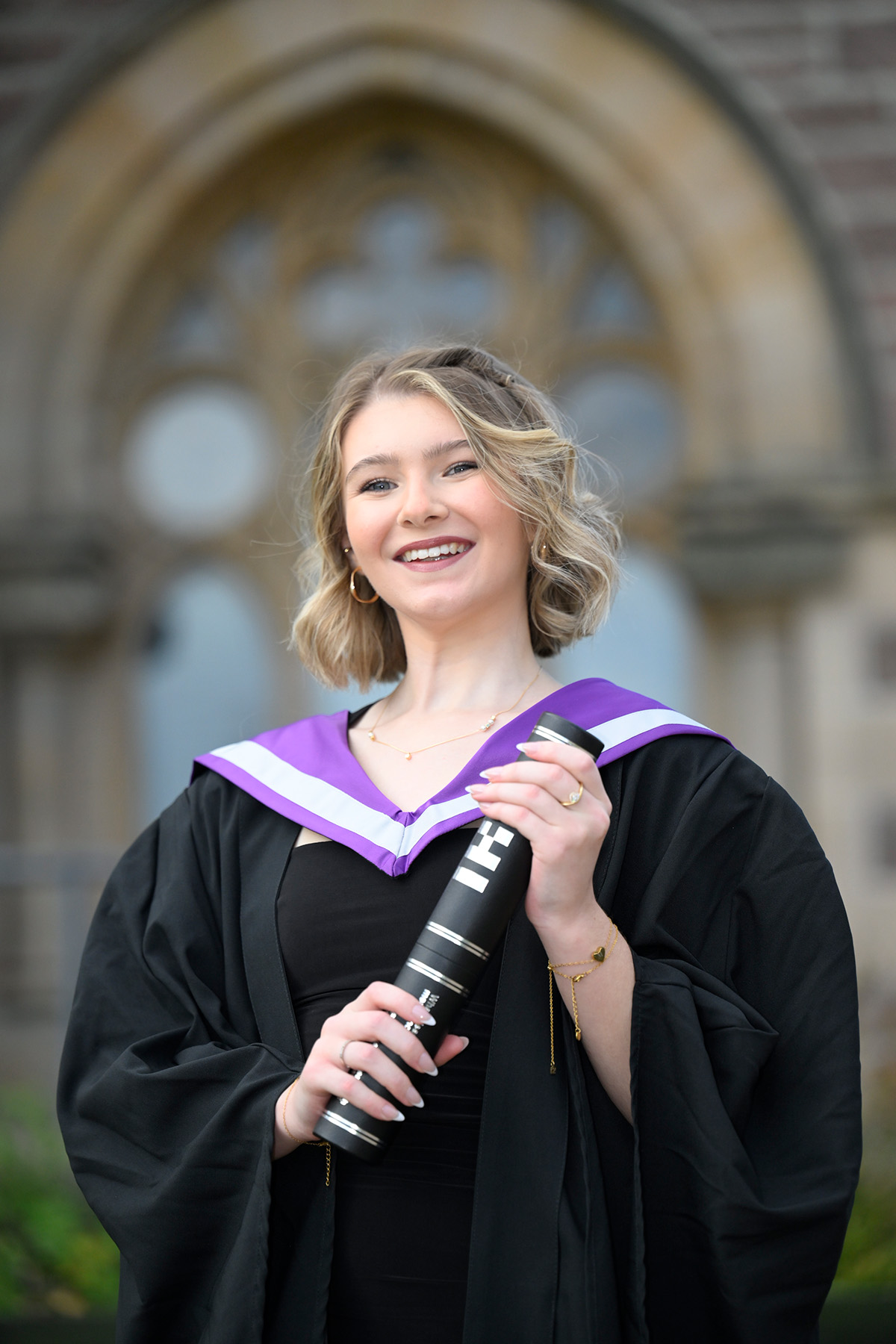 Graduate Megan Short holding a scroll