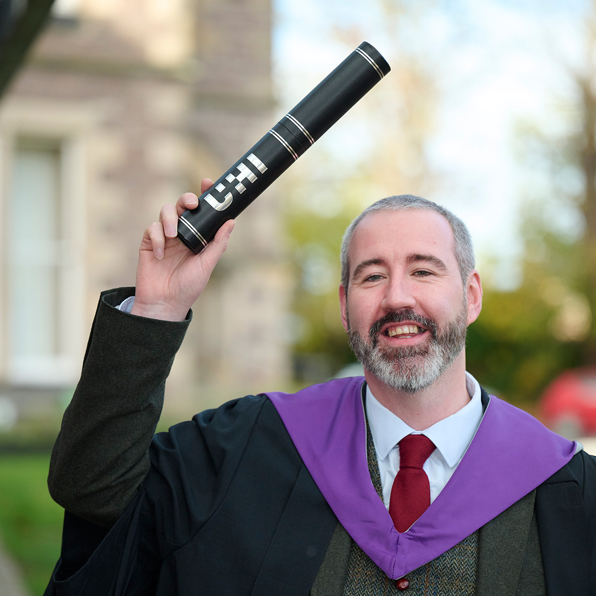 Steven Clelland wearing a robe and holding a scroll