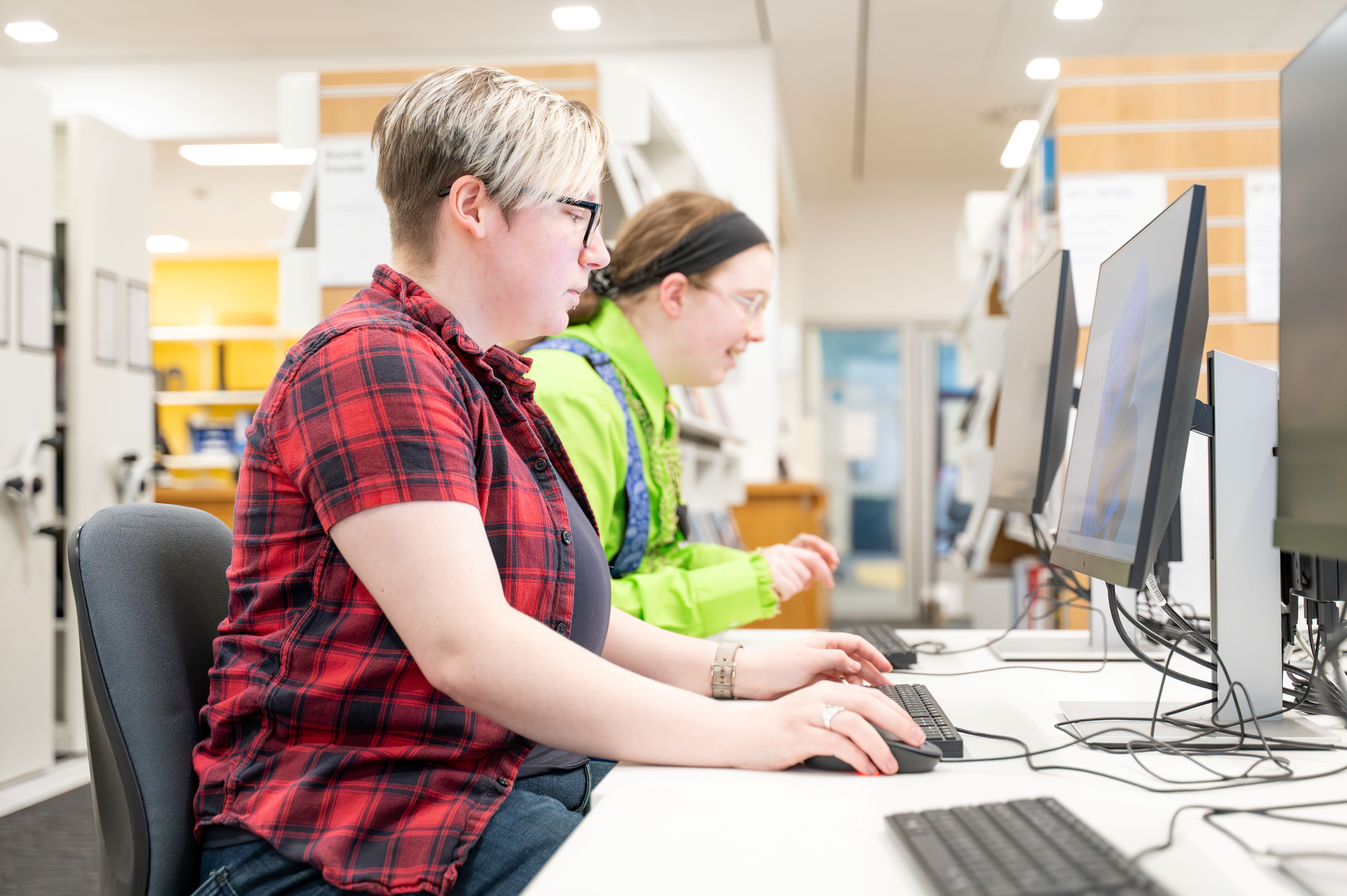 two students looking at computers two students looking at computers