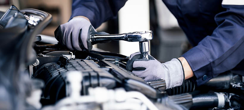 Mechanic working under bonnet of a car Mechanic working under bonnet of a car