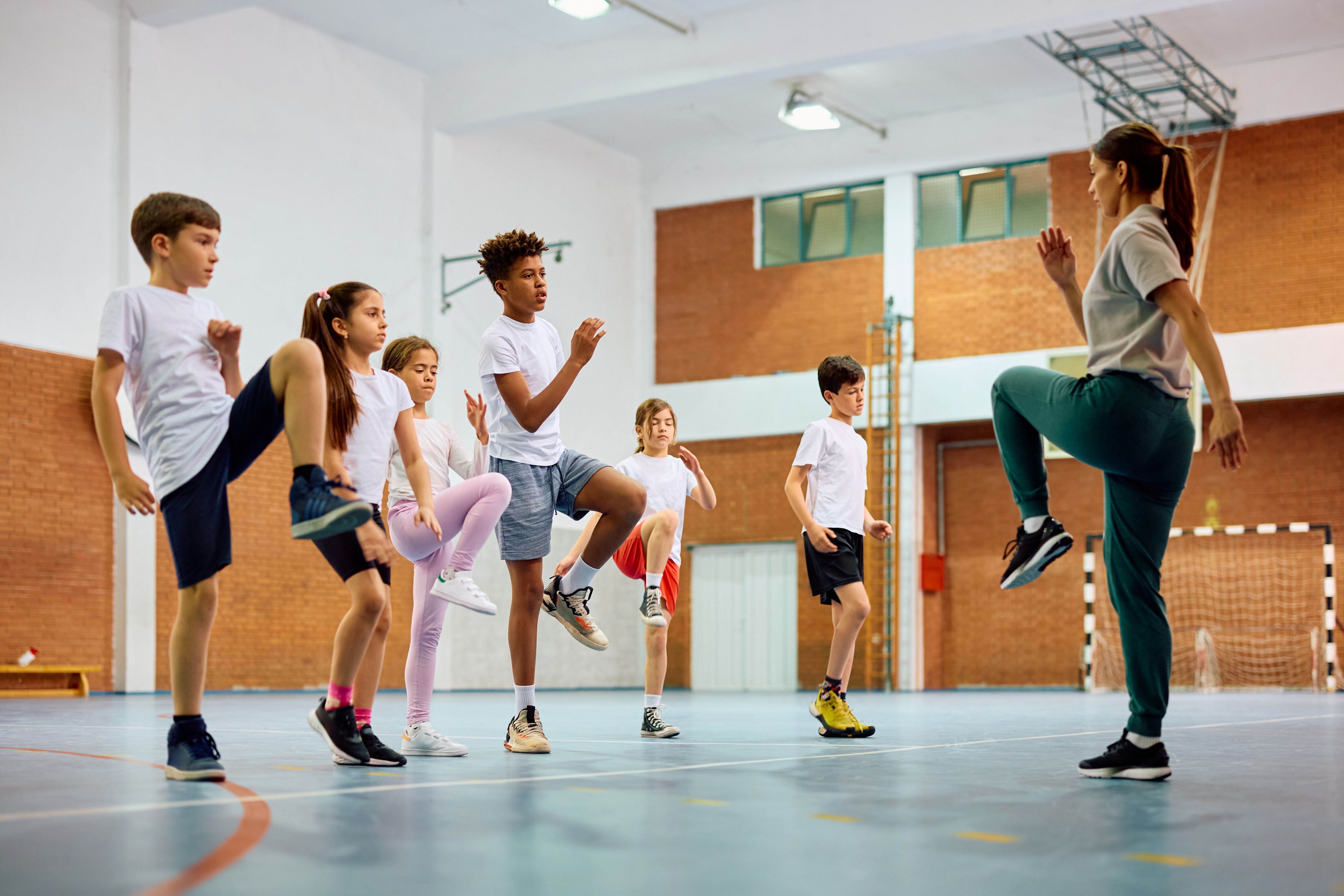 pupils being taught to knee kick in a sports hall pupils being taught to knee kick in a sports hall